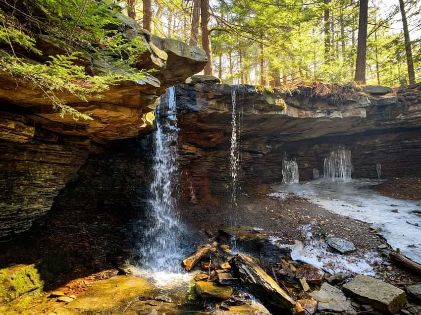 Adams Falls with someone standing behind the waterfall