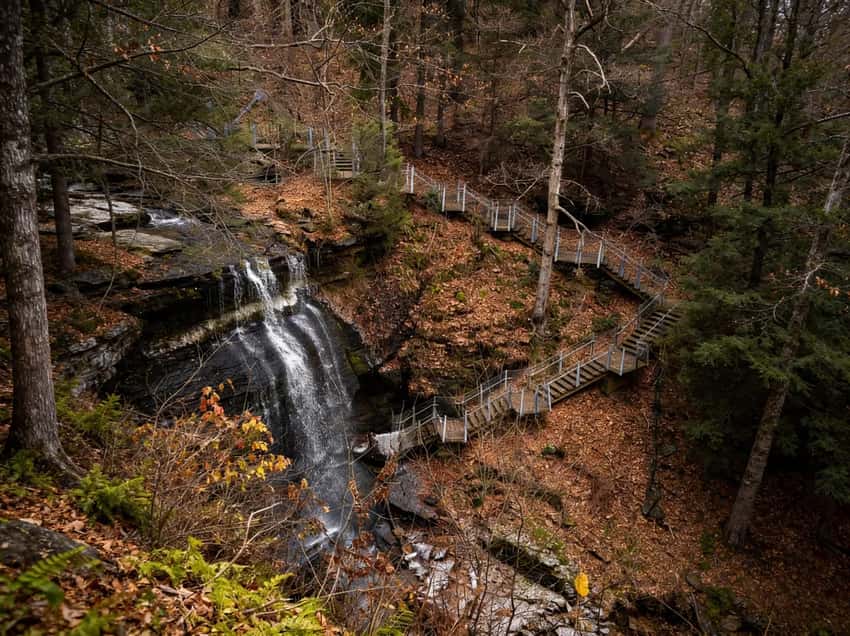 The iconic Buttermilk Falls in Indiana County: A 45-foot cascade with a dedicated walkway passing behind the curtain of water.