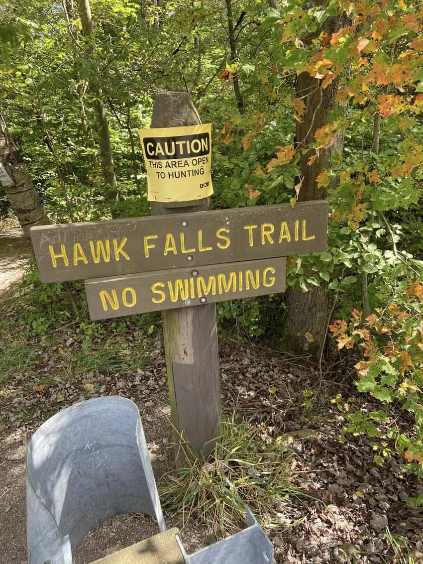 The yellow Hawk Falls trailhead sign on PA Route 534